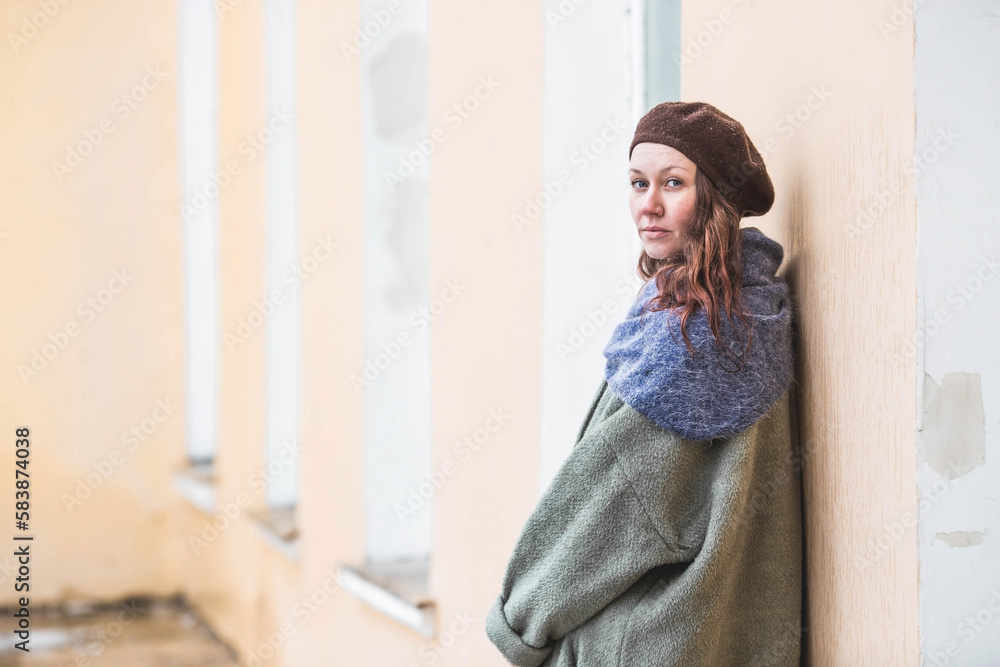 Portrait of a cute young woman in a beret in early spring outdoors . A girl with loose hair and a long coat on the background of an old manor. Portrait of a cute young woman in a beret in early spring outdoors . A girl with loose hair and a long coat on the background of an old manor.