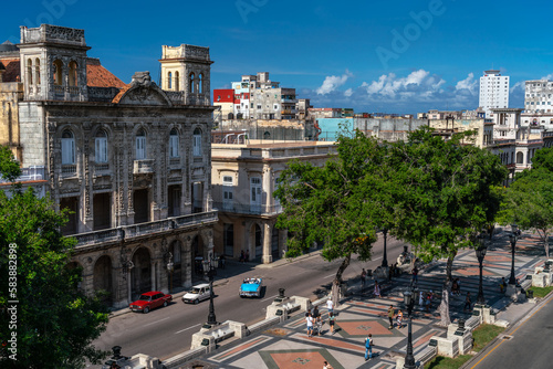 Paseo del Prado, aerial view with promenaders and blue classic car full of tourists, Havana photo