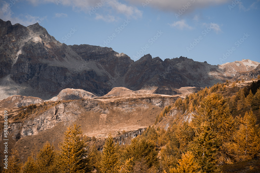 Clouds partially obscure the mountain peaks in the Alpe Devero, Northern Italy, during autumn