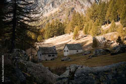 A couple of small mountain huts in the highland of Alpe Devero  Northern Italy  with high peaks in the background