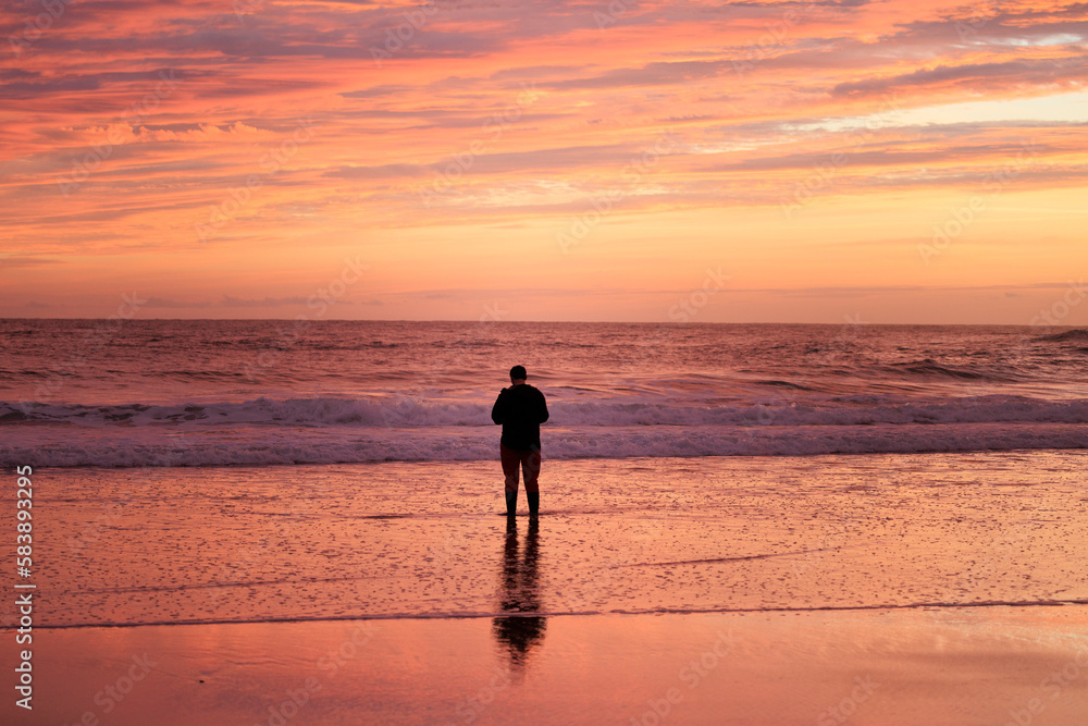 Persona observando el mar al amanecer