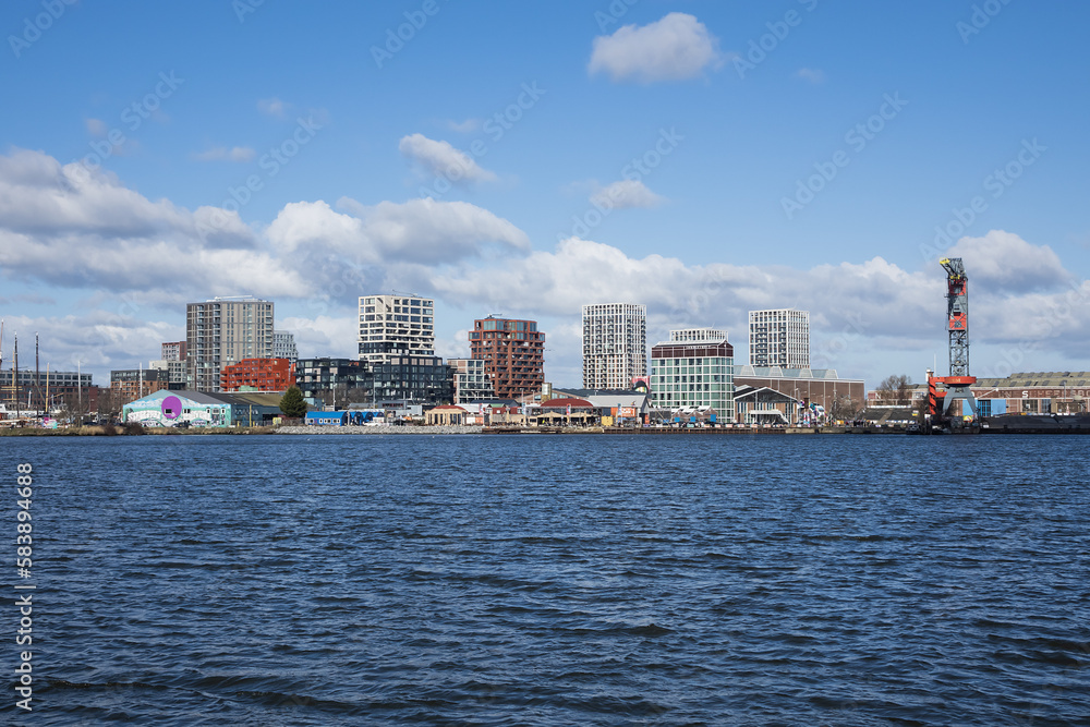 Panoramic view from the IJ river to NDSM neighborhood (Amsterdam-Noord borough), located on the former terrain NDSM-wharf, along the IJ river. AMSTERDAM, The NETHERLANDS.