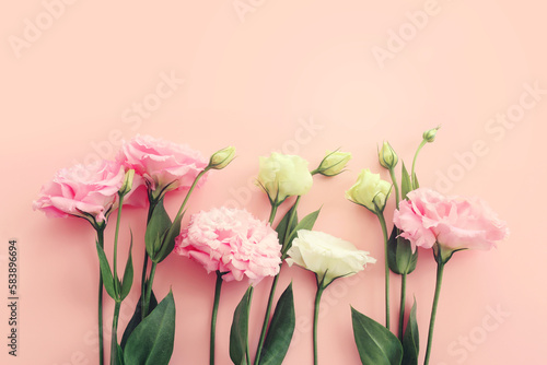 Top view image of delicate pink flowers over pastel background