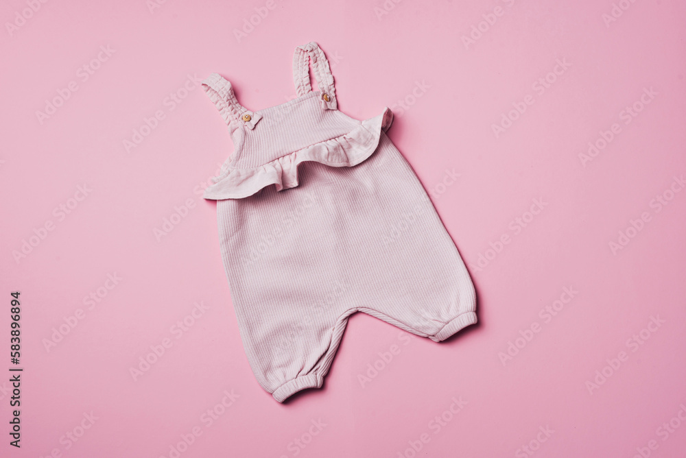 Pink baby girl romper on pastel backgroundd. Set of baby clothes and accessories for spring or summer. Fashion childs outfit. Flat lay, top view. Copy space Pink baby girl romper on pastel backgroundd. Set of baby clothes and accessories for spring or summer. Fashion childs outfit. Flat lay, top view. Copy space