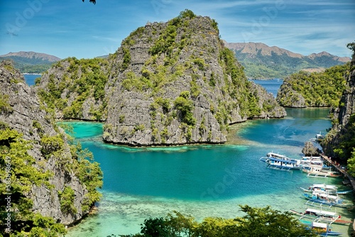 A bay with majestic rocks in Coron, Palawan in the Philippines that are overgrown with shrubs and rise out of the water.