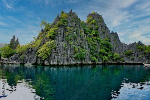 Fotografie Majestic rocks in Coron, Palawan in the Philippines that are overgrown with shrubs and rise out of the water