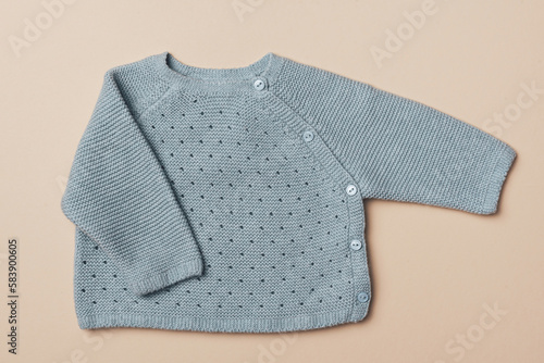 Knitted blue sweater. Set of baby stuff and accessories for newborn on beige backgroundd. Baby shower or baby care concept. Fashion newborn. Flat lay, top view