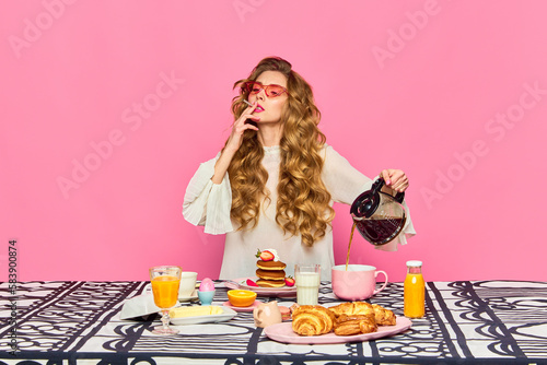 Redheaded girl with sunglasses preparing coffee and smoking cigarettes over pink background