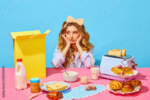 Image of upset girl in homewear and bow propping up cheeks and looking away from food on pink tablecloth over light blue background photo