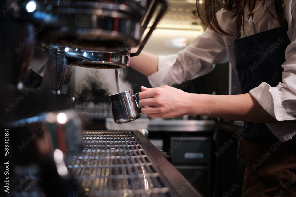 Close up of a barista heating milk for coffee in a cafe on a coffee machine. Close up of a barista heating milk for coffee in a cafe on a coffee machine.