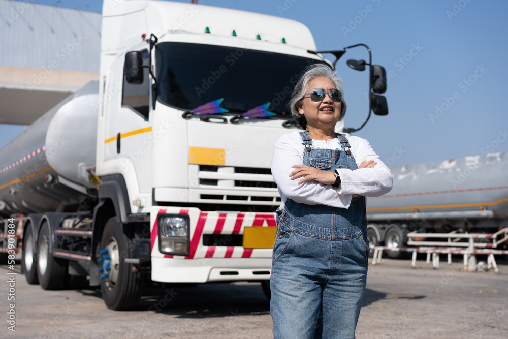 Business owner standing in front of oil truck after performing a pre-trip inspection on a truck. Concept of preventive maintenance. Business owner standing in front of oil truck after performing a pre-trip inspection on a truck. Concept of preventive maintenance.