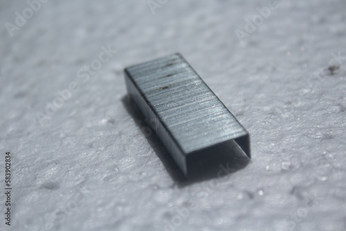 portion of metal staples on a white background