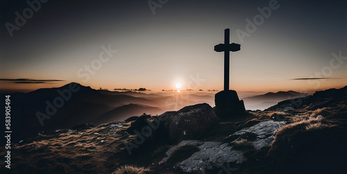 A religious cross on top of a mountain at sunset