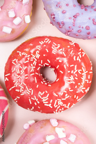 Donuts with red and pink glaze, top view. Lots of donuts, sweet and delicious food