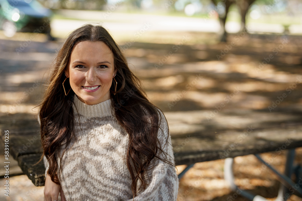 Beautiful young female model posing in the park in the animal print sweater Beautiful young female model posing in the park in the animal print sweater