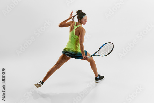 Portrait of young athletic woman, professional female tennis player training against white studio background. Game. Concept of professional sport, movement, health, action, competition. Ad © master1305