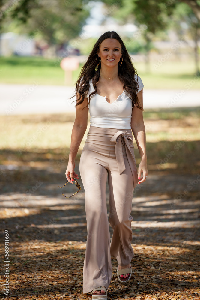 Beautiful young female walking in the park after work Beautiful young female walking in the park after work