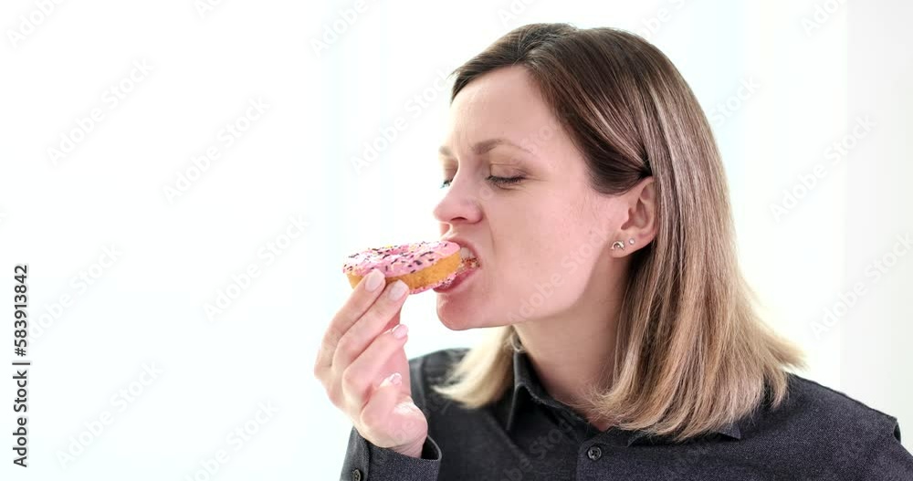 Woman enjoying eating sweet tasty donut on white background 4k movie slow motion Woman enjoying eating sweet tasty donut on white background 4k movie slow motion
