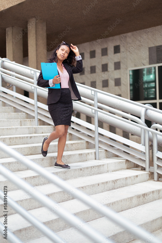 Elegant young adult latina woman walking in the street. Entrepreneurial person, businesswoman.