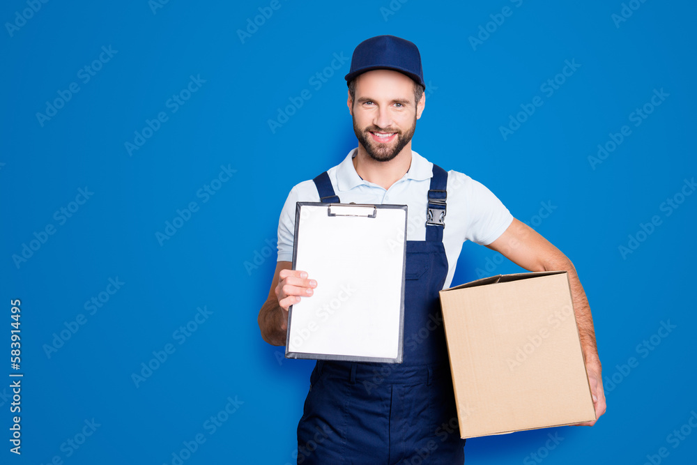 Portrait with empty place, copyspace of cheerful, attractive man having, carrying box in hands demonstrate clean paper in clipboard, looking at camera, isolated on grey background Portrait with empty place, copyspace of cheerful, attractive man having, carrying box in hands demonstrate clean paper in clipboard, looking at camera, isolated on grey background