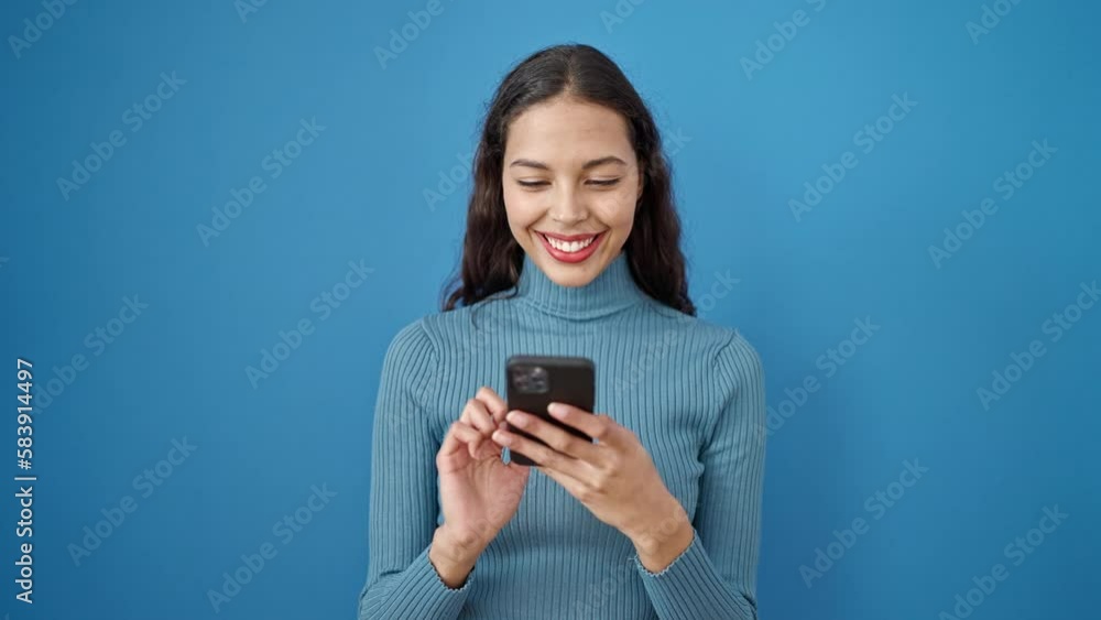 Young beautiful hispanic woman using smartphone over isolated blue background Young beautiful hispanic woman using smartphone over isolated blue background