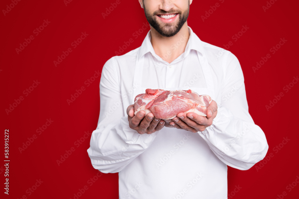 Close up cropped portrait of cheerful half face butcher demonstrate fresh meat in his arms, isolated on grey background, advertisement concept