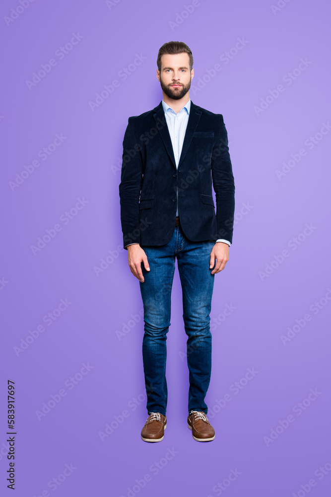 Full size body portrait, snap of attractive trendy teacher with stubble, looking at camera, isolated over grey background, wearing jacket, jeans, shirt