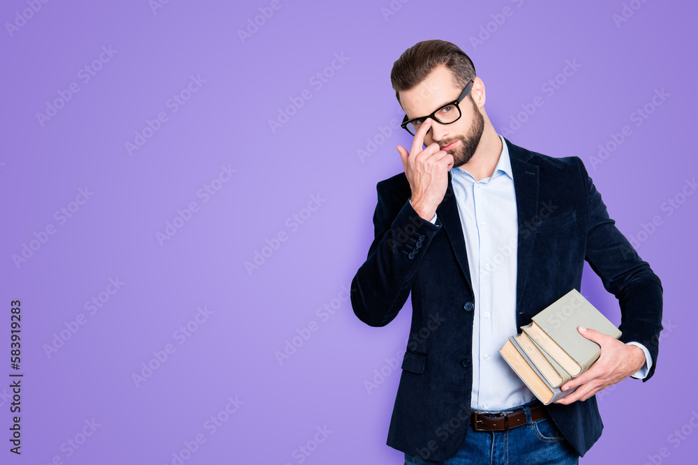 Portrait with copyspace, empty place of attractive stylish teacher fixing his glasses on face with finger, having books in hand, wearing shirt, jacket, jeans, isolated on grey background Portrait with copyspace, empty place of attractive stylish teacher fixing his glasses on face with finger, having books in hand, wearing shirt, jacket, jeans, isolated on grey background