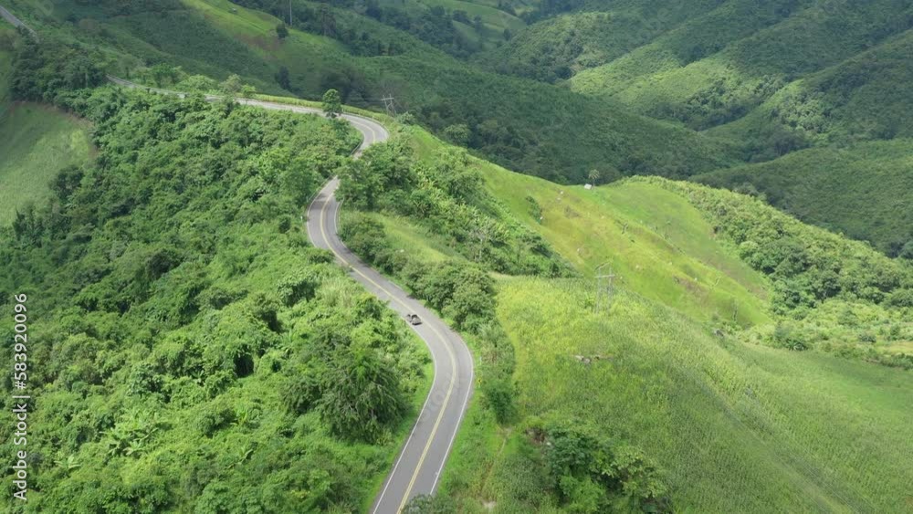 Aerial view of countryside road passing through the lush greenery and foliage tropical rain forest mountain landscape in the Nan Province Northern Thailand Aerial view of countryside road passing through the lush greenery and foliage tropical rain forest mountain landscape in the Nan Province Northern Thailand