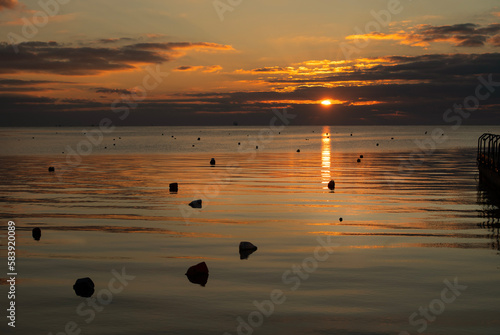 Obraz na plátne Beautiful sunset above the sea or lake: Amazing evening travel scene with the low sun reflected in the water and an orange sky