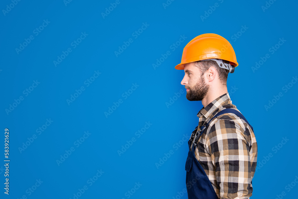 Profile portrait with copy space, empty place for advertisement, product of virile harsh repairer in shirt and overall isolated on grey background