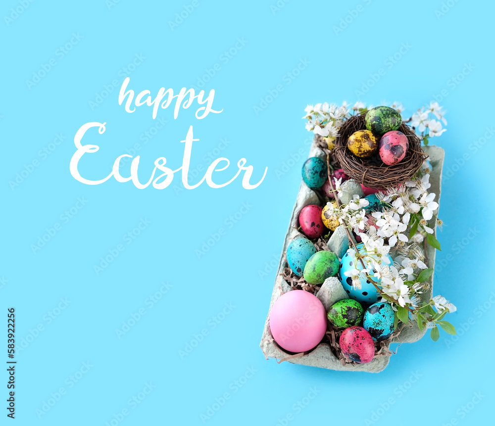 Fototapeta premium Happy Easter greeting card. colorful eggs, nest, cherry flowers in carton box on blue background. Easter holiday concept. symbol of spring festive season.