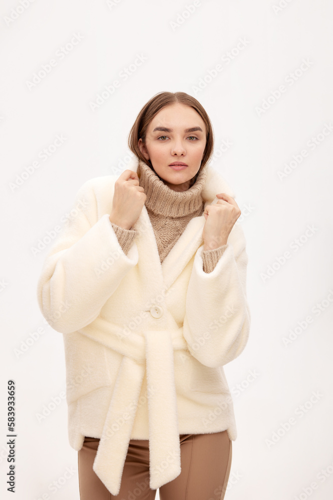 Close-up of a modern business woman on a light background in fashionable faux fur clothes, fashion, modern urban style