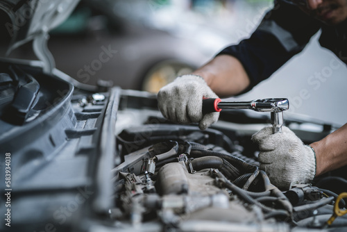 Obraz na plátne Close-up photo of a car mechanic working on a car engine in a mechanics repair service garage