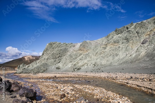 River running through a rocky valley next to a mountain