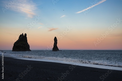 Beautiful view of huge rocks in a sea under the clear sky during sunset