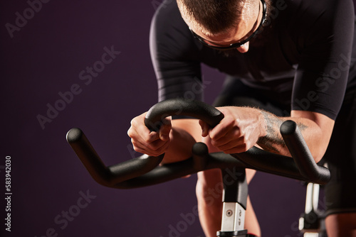 Legs and arms of a man on an exercise bike close-up