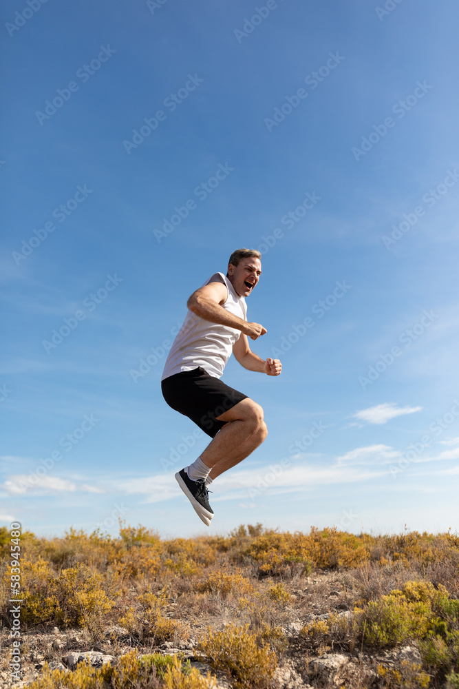 A man jumps and shouts to de-stress while exercising in the countryside to keep fit and lead a healthy lifestyle