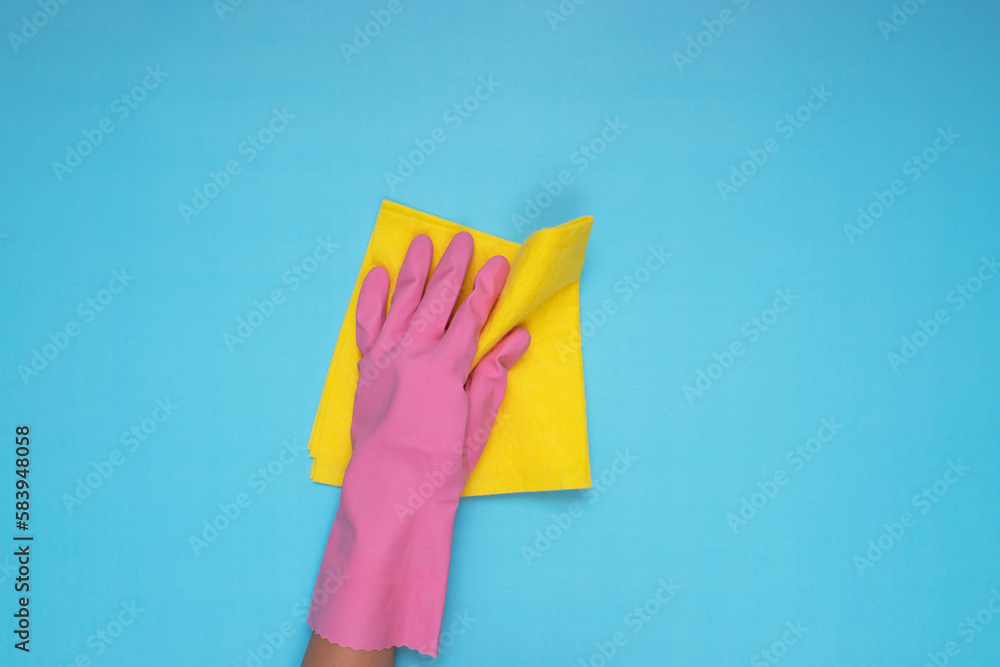 woman wearing pink cleaning gloves on light blue background, holding cleaning cloth woman wearing pink cleaning gloves on light blue background, holding cleaning cloth