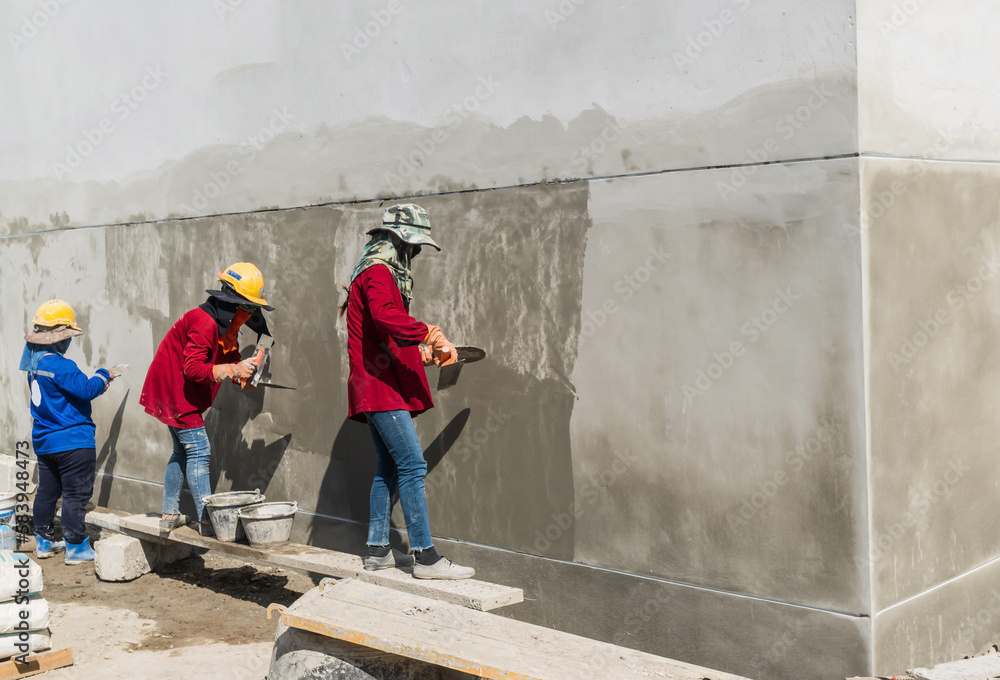 Builders are applying precast mortar to the walls of buildings to give a smooth and even finish to the walls. Plastering the building walls requires resolution and expertise in the work. Builders are applying precast mortar to the walls of buildings to give a smooth and even finish to the walls. Plastering the building walls requires resolution and expertise in the work.