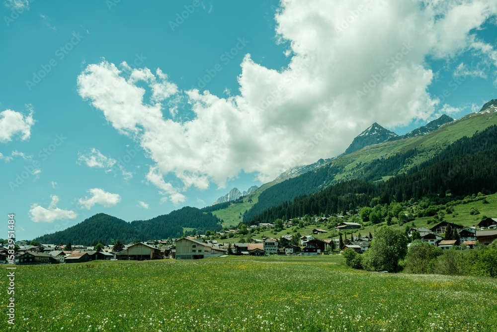 Scenic shot of a houses in a field on the foot of Brigels Breil Mountains in Grisons, Switzerland