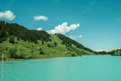 Beautiful view of the Lag da Beil lake under a blue sky in the Swiss mountains in the Surselva area
