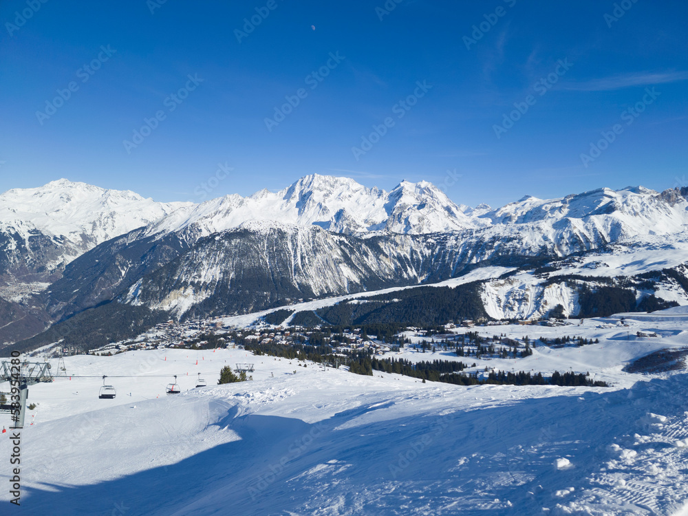 Top view of Courchevel ski area in French alpine Three Valleys resort, with snowy slopes, pine trees, chair lifts .