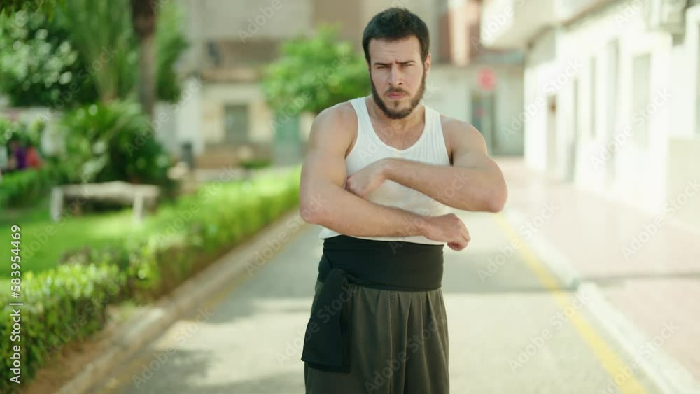 Young hispanic man karate fighter standing with arms crossed gesture at park Young hispanic man karate fighter standing with arms crossed gesture at park
