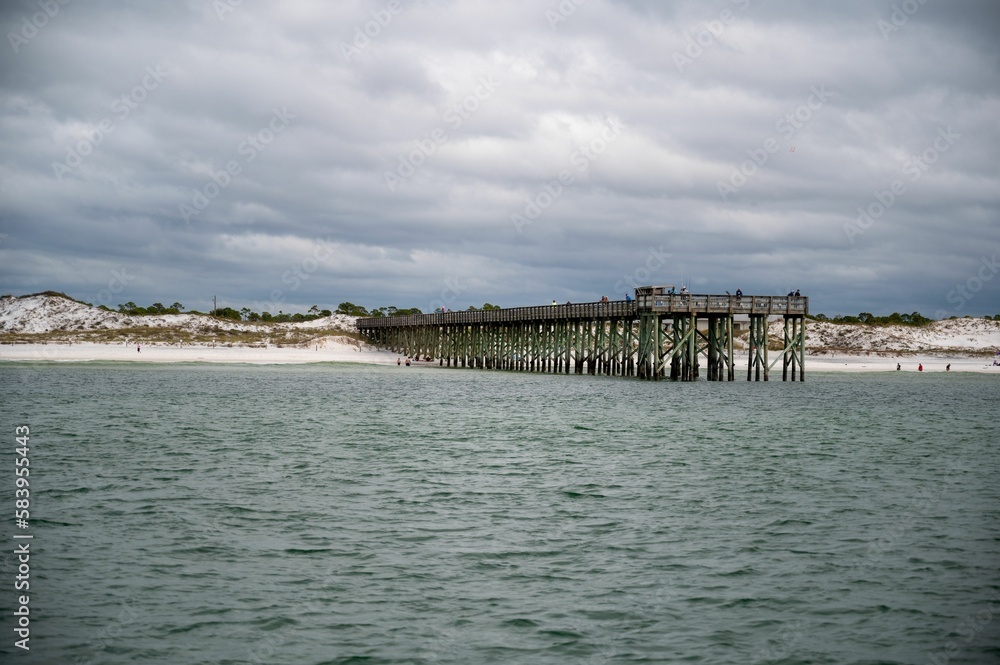 Natural view of old dock and beach under a cloudy day