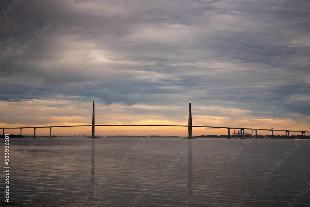 Scenic view of long bridge across the water at sunset