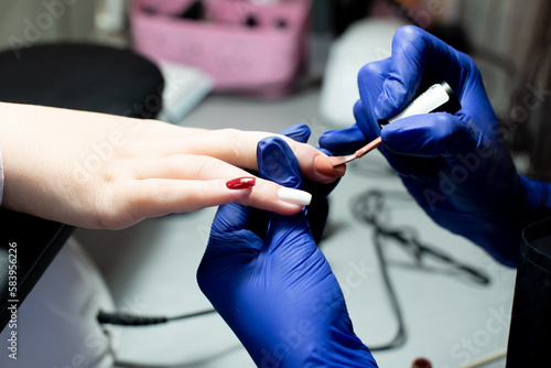 Professsional nails care in beauty salon.Manicurist paints fingernails. Process of making nail design with art. 