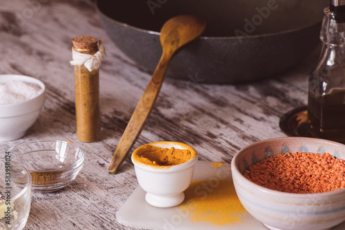 Turmeric, red lentils (dhal) and curry spices on a kitchen table