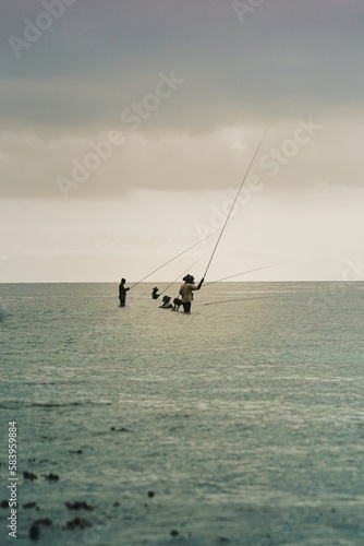 Men throwing fishing rods into the sea