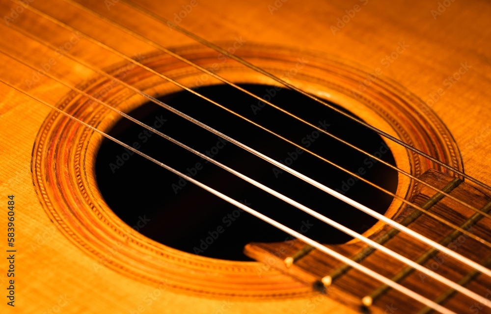 Closeup shot of details on a wooden brown acoustic guitar Closeup shot of details on a wooden brown acoustic guitar